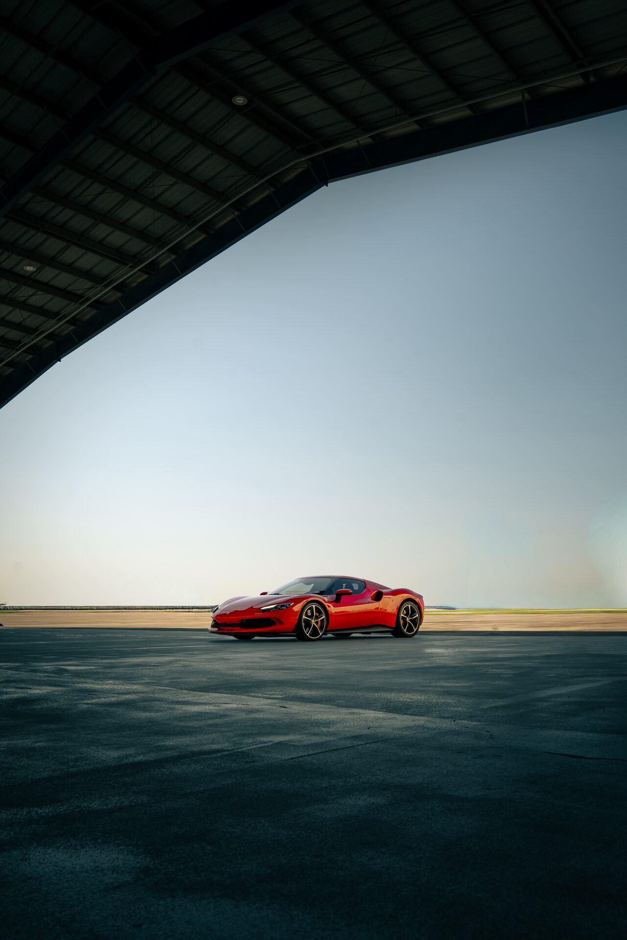 Red Ferrari at dusk on open road