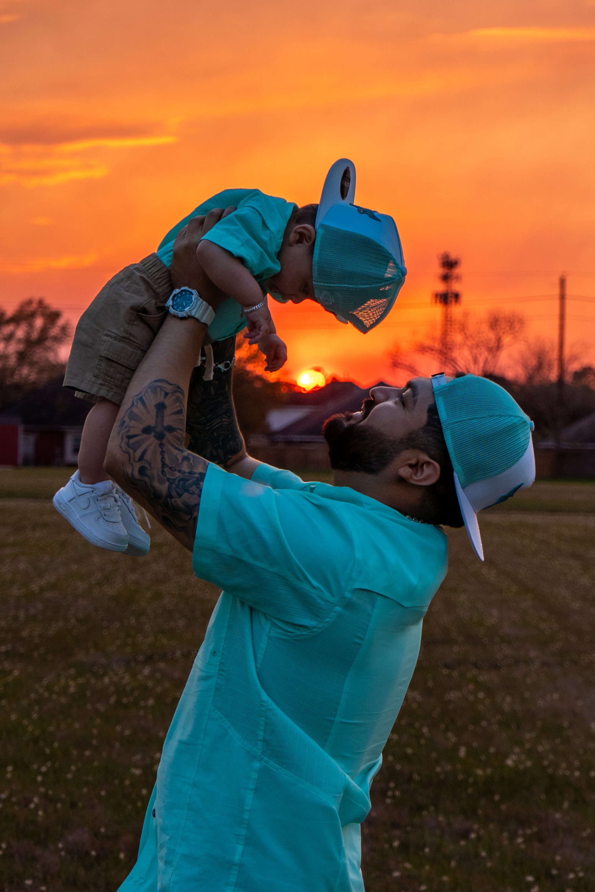 Father tossing baby at sunset, action shot