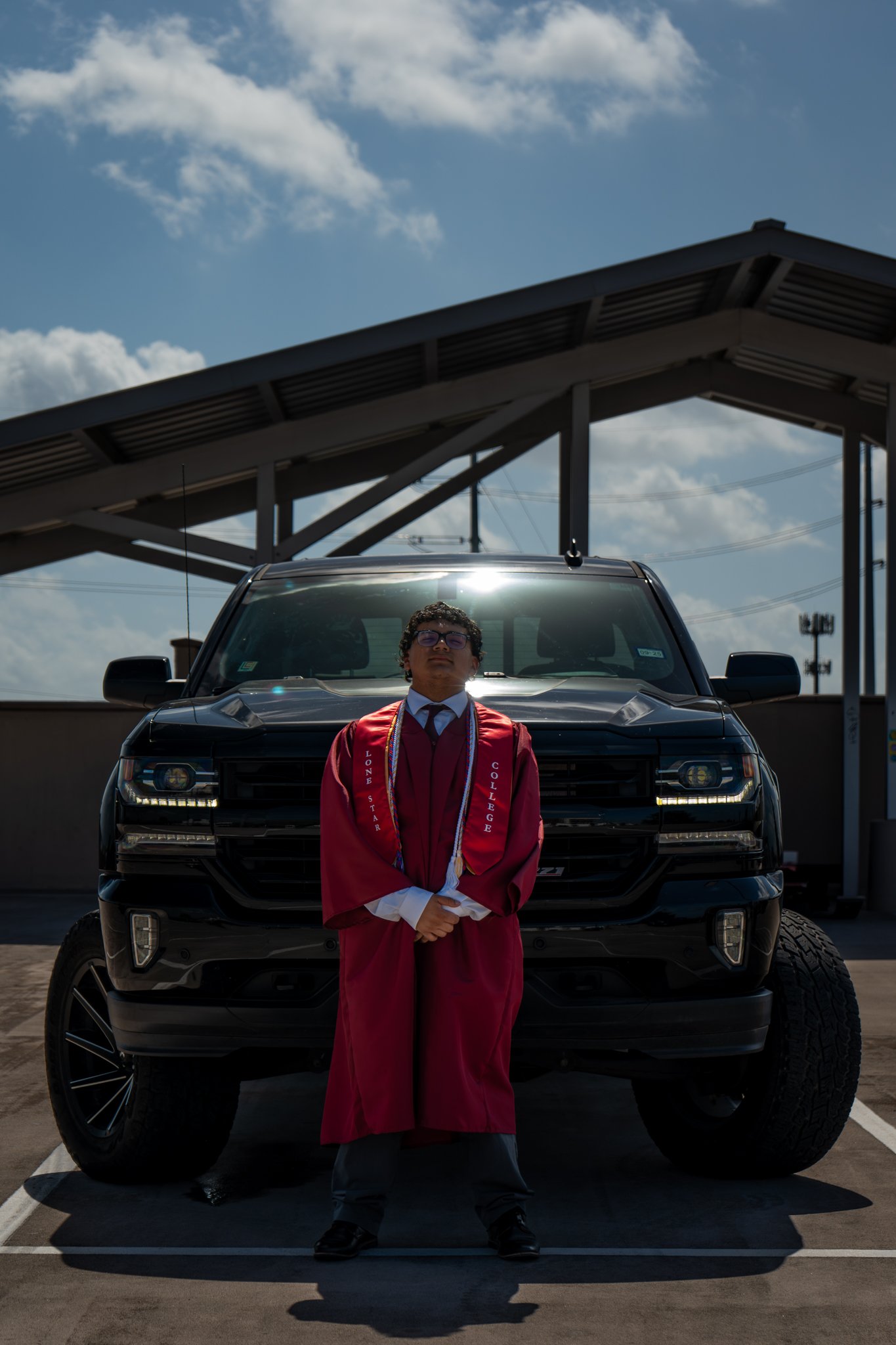 Graduate in red gown on truck bed