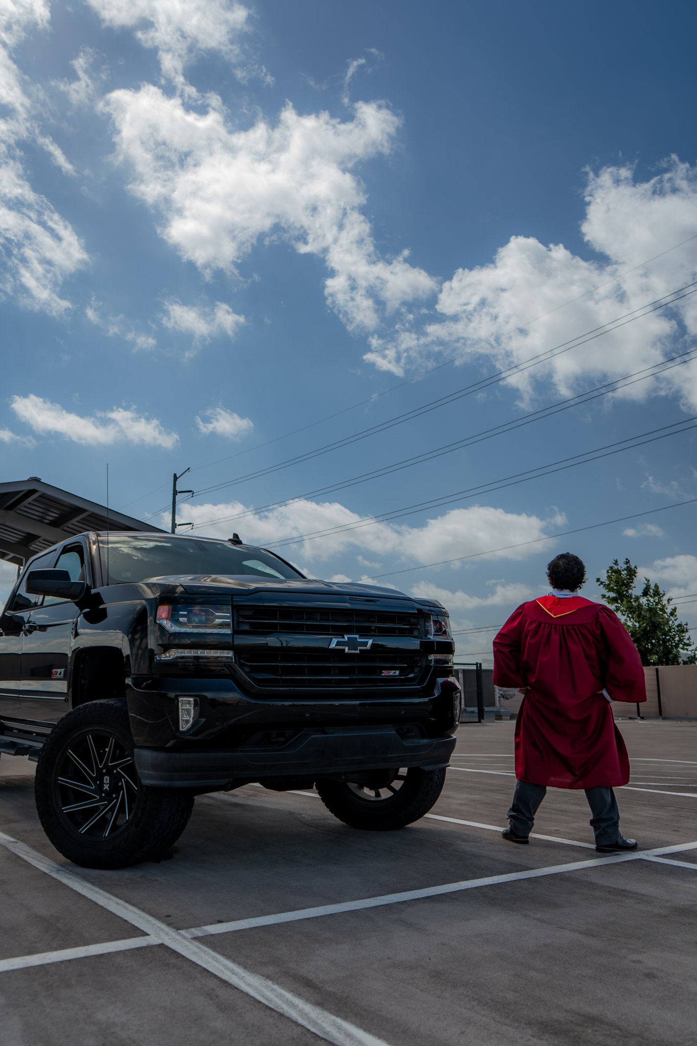 Graduate walking away from truck, wide dramatic shot