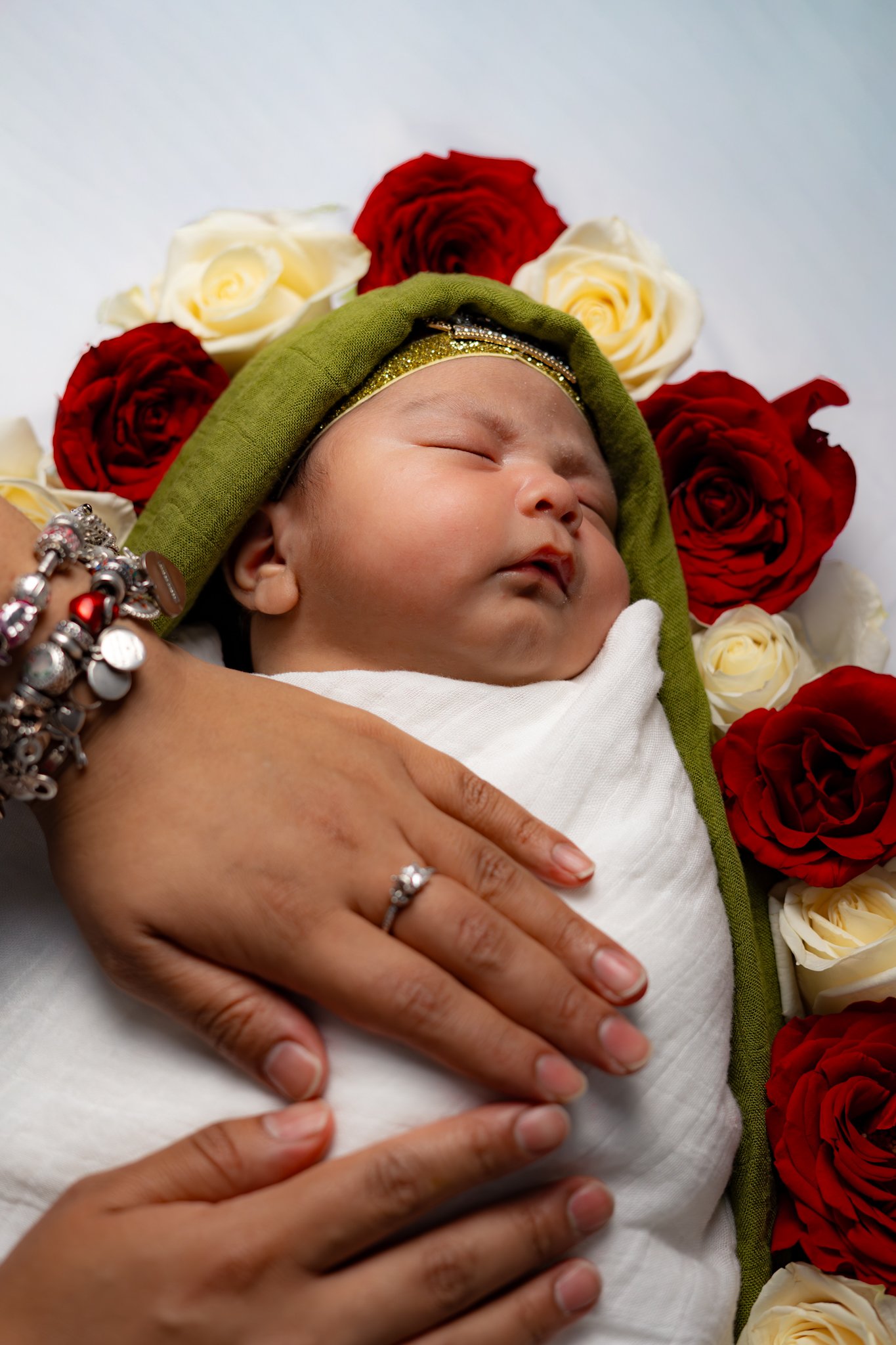 Newborn portrait with parent's hand resting on baby
